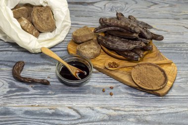 Sağlıklı diyet yiyecek. Un, kraker ve keçiboynuzu Pod ahşap arka plan yakın çekim üzerinde şurubu