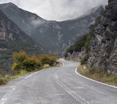 Bir dar, kırsal yol kış bulutlu gün (Yunanistan, Peloponnese, dağ silsilesi Taygetus dağlarında).