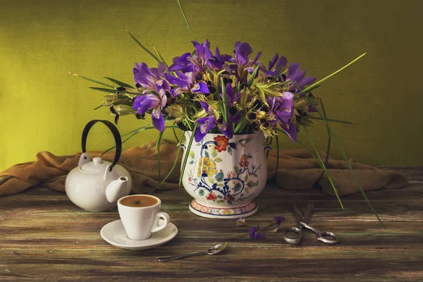 Het boeket van gele irissen en violet kleur close-up en cup o — Stockfoto