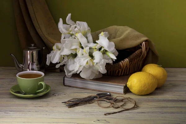 Букет белые ирисы, лимоны и чашку чая крупным планом — стоковое фото