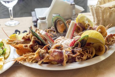 Büyük bir tabak yakın çekimde farklı, kızarmış deniz ürünleri