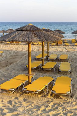 Bir yaz akşamı şezlong ve şemsiye ile Kumlu plaj (Pel