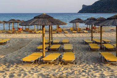 Bir yaz akşamı şezlong ve şemsiye ile Kumlu plaj (Pel