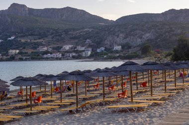 Bir yaz akşamı şezlong ve şemsiye ile Kumlu plaj (Pel