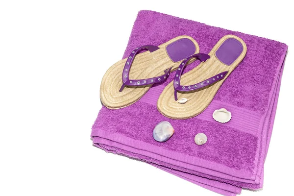 Een paar nieuwe, Lila vrouwen slippers voor het strand en een handdoek — Stockfoto