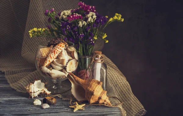 Ahşap masada çeşitli deniz kabuğu ve yaban çiçekleri — Stok fotoğraf