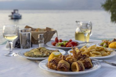 Kızarmış kalamar, kızarmış kabak, patates kızartması, salata ve g akşam yemeği
