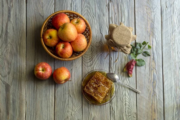 Банка с медом и яблоками в плетеной корзине крупным планом — стоковое фото
