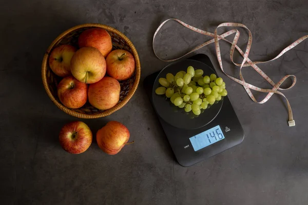 The electronic, black kitchen scale, apples, grape and centimete — Stock Photo, Image