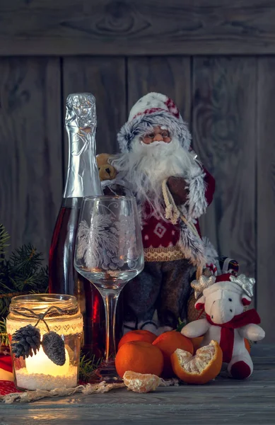 Os ramos de abeto, tangerinas, Papai Noel e champanhe em um close-up de mesa . — Fotografia de Stock