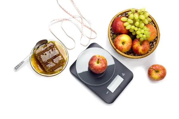 The electronic, black kitchen scale, apples, grape and centimeter, grape and honey comb — Stock Photo, Image