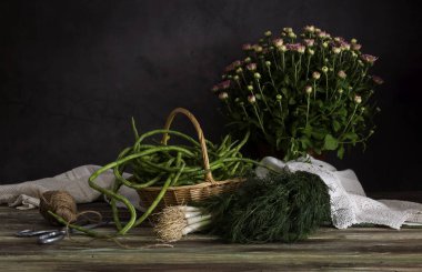 Taze fasulye deresi ve yeşil soğan ahşap bir masada.