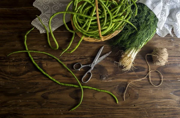 Taze fasulye deresi ve yeşil soğan ahşap bir masada. — Stok fotoğraf