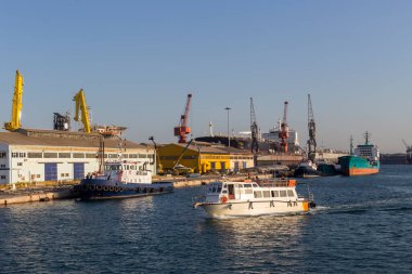 Güneşli bir yaz gününde liman manzarası, park halindeki gemiler, marina ve yolcu gemisi (Perama, Yunanistan)