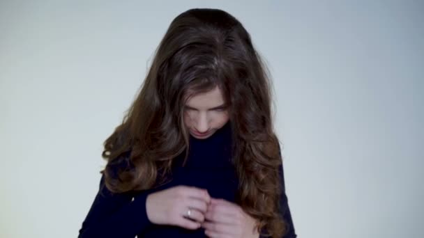 Schönes junges Mädchen wirft die Haare hoch und lächelt fröhlich in die Kamera — Stockvideo