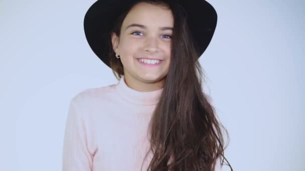 Menina bonita no chapéu alegremente posa na câmera . — Vídeo de Stock