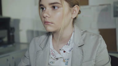 Genç kız klavyede yazarak ve Office kamera bakıyor. 4k