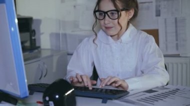 Klavyede yazarak ve diyagramlarını kullanarak meşgul gülümseyen kız