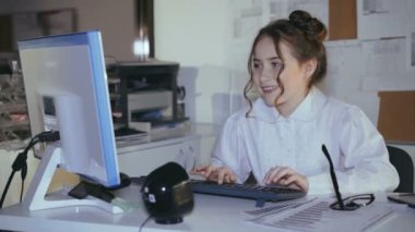 Klavyede yazarak ve diyagramlarını kullanarak meşgul gülümseyen kız. 4k