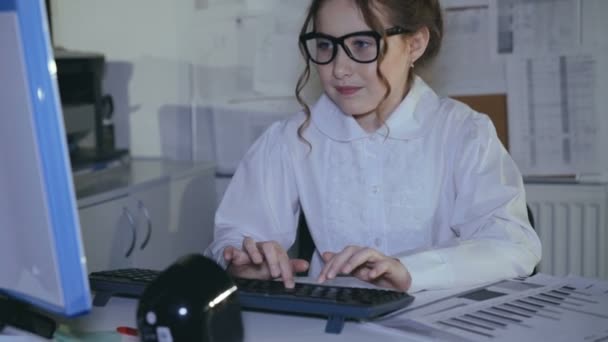 Emsiges lächelndes Mädchen tippt auf der Tastatur und benutzt Diagramme — Stockvideo