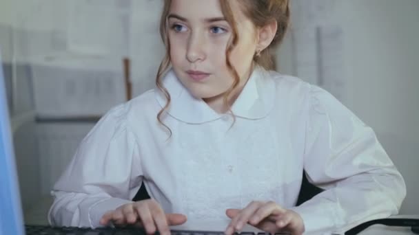 Молодая девушка охотно печатает на клавиатуре и улыбается в камеру. 4K — стоковое видео