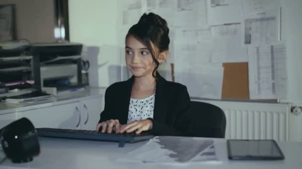 Stylish successful schoolgirl willingly works with pc and smiles at camera — Stock Video