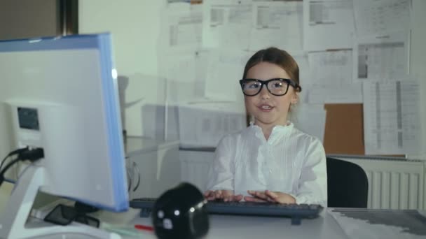 Little business girl fast types on keyboard and shows thumbs with smile — Stock Video