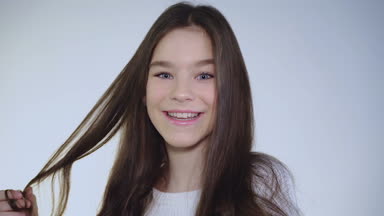 Genç ve güzel esmer saçlarını çalış ve kameraya coquets