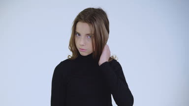 Uzun saçlı şık çekici kız kameraya poz veriyor.