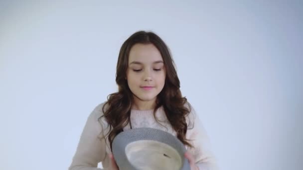 Pretty young girl plays with hat and wears on head with cute smile — Stock Video