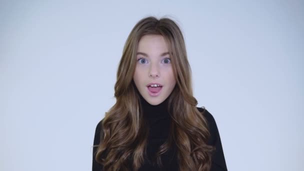 Portrét překvapení dívka opravuje její vlasy a kývne hlavou na kameru — Stock video