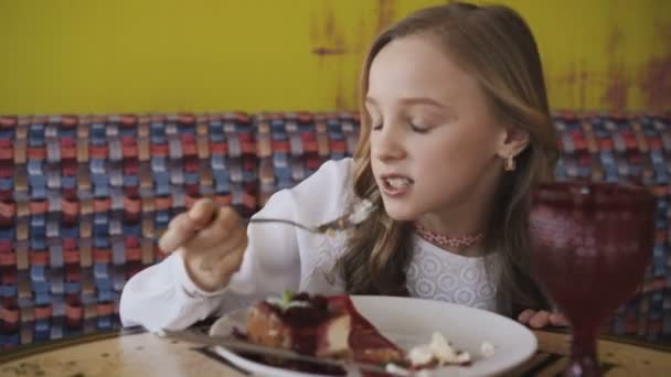 Chica bonita comiendo sabroso postre y mirando a la ventana. 4K — Vídeos de Stock