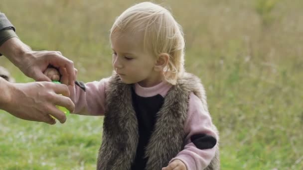 Portret van gelukkig, glimlachen klein kind blaast de bubbels op aard — Stockvideo