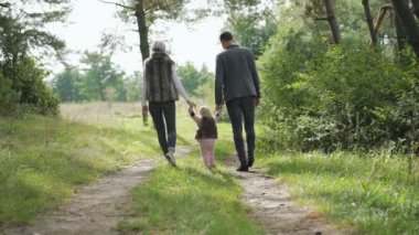 Mutlu bir aile ile küçük çocuklarının üzerinde doğa yürüyüşleri. Yavaş yavaş