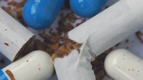 Zusammensetzung von Tabletten und zerrissenen Zigaretten mit rotierendem Tabak — Stockvideo