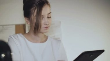 Sevimli kız kameraya tablet ve gülümsüyor ile çalışır. 4k