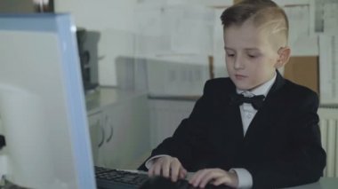 Küçük başarılı işadamı ofiste pc çalışır. 4k