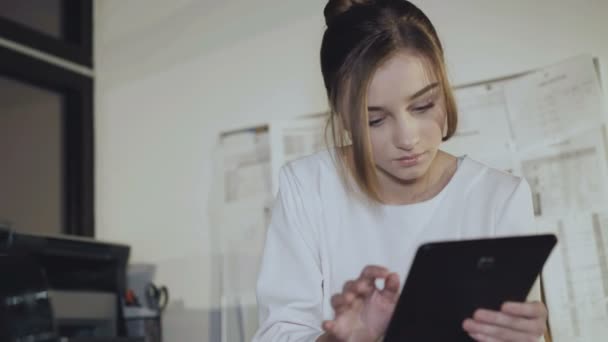 Chica ocupada trabaja con diagramas y tableta en la oficina. 4K — Vídeo de stock