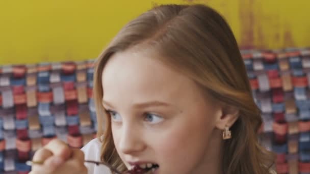 Menina Feliz Comendo Sobremesa Saborosa Sorrindo Para Câmera Devagar — Vídeo de Stock