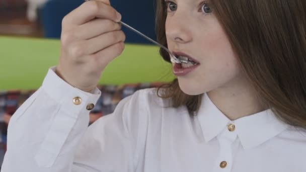 Porträt eines glücklichen jungen Mädchens, das leckeres Dessert mit Vergnügen isst — Stockvideo