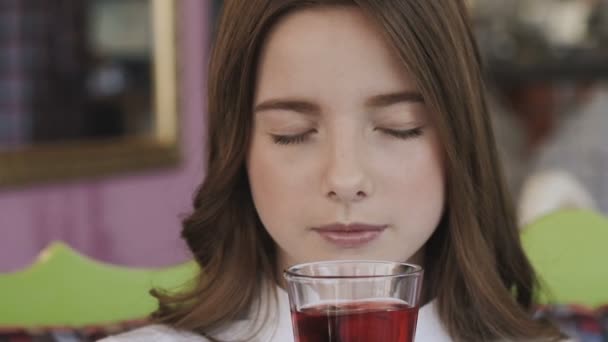 Close up ritratto di giovane ragazza beve un succo di frutta con piacere — Video Stock