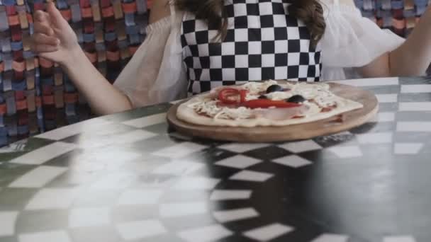 Glimlachend meisje spinnen de pizza en glimlachend in de camera in café — Stockvideo