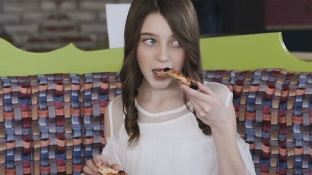Rapariga bonita a comer pizza no café. Devagar. — Vídeo de Stock