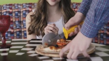 Mutlu kız nasıl pizza onun için dilimleme kafede garson. Yavaş yavaş