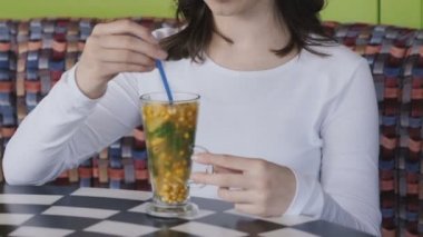 Güzel kız kafede tat içecek tübül ile karıştırma. Yavaş yavaş