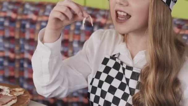 Vista de chica agarra un poco de queso de una pizza — Vídeos de Stock