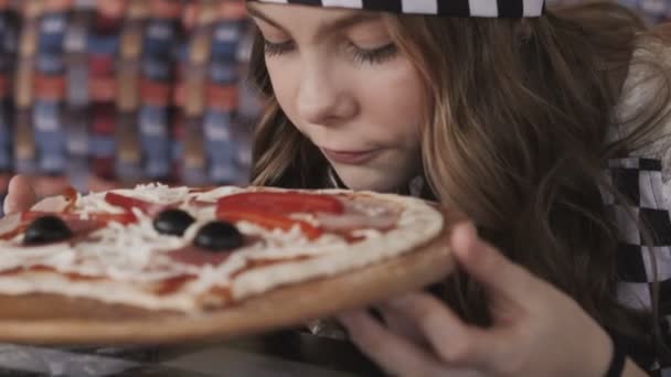 Mooie jonge meisje geniet van de geur van een pizza. Langzaam — Stockvideo