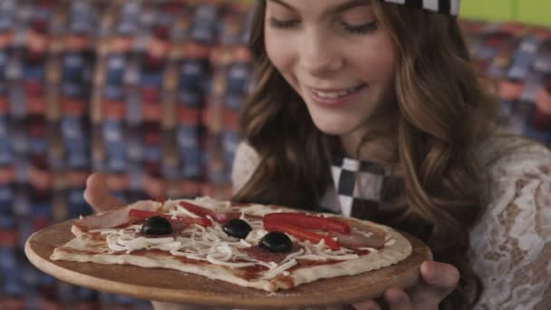 Mooie jonge meisje geniet van de geur van een pizza. Langzaam — Stockvideo