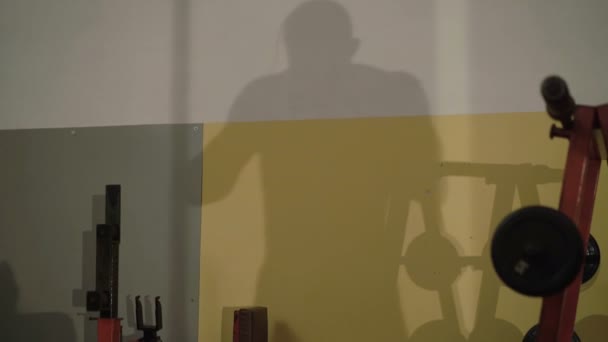 Silhouette på väggen i sportsmanen träning i gymmet. 4k — Stockvideo