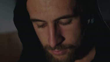 Güçlü kamera siyah pelerin terli bir adamın karanlıkta bakın. 4k